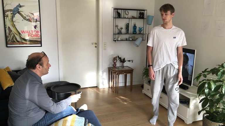 ung mand går ind foran tv