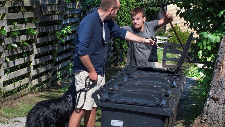 mand smider hundepose i anden mands affaldsbeholder