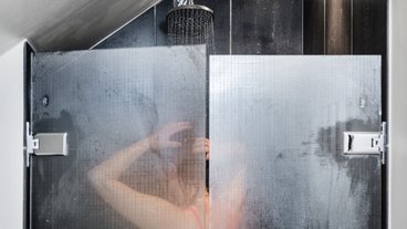 kvinde tager brusebad og sparer på vandet