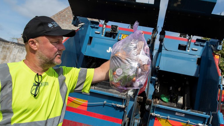 renovationsarbejder tjekker skrald i affaldspose