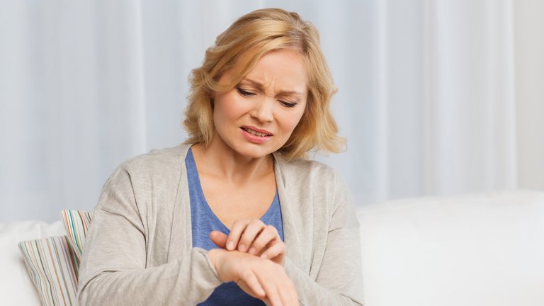 Kvinde klør sit håndled på grund af fnat