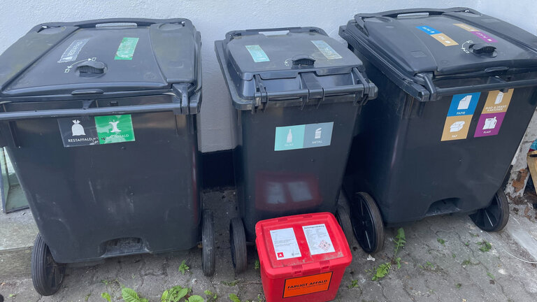 Affaldsbeholdere uden for et hus